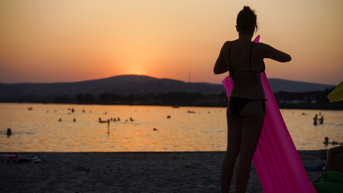 Egy strandoló a Velencei-tó partján naplementekor a Velence Korzó és Szabadstrandon 2015. július 6-án. Az országos tiszti főorvos július 4-től július 8-án éjfélig hőségriadót rendelt el, mert ebben az időszakban eléri vagy meghaladja a napi középhőmérséklet a 27 Celsius-fokot.
