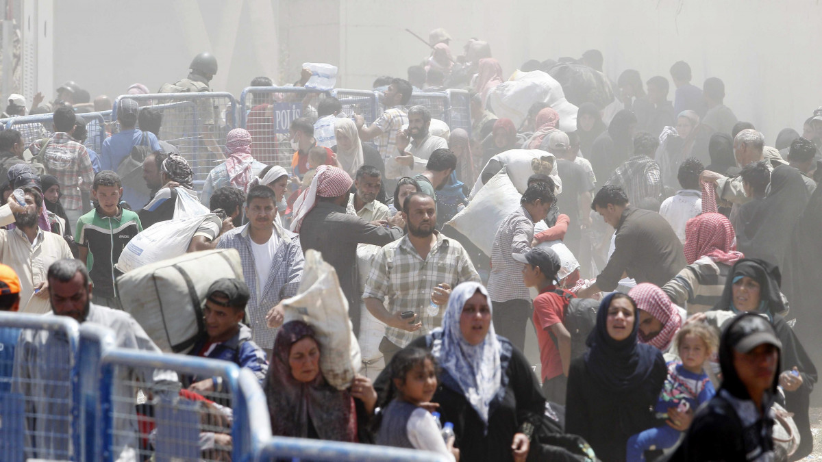 Akcakale, 2015. június 15.Szíriai menekültek lépik át a határt a délkelet-törökországi Akcakalében 2015. június 15-én. A határ túloldaláról az Iszlám Állam szélsőséges iszlamista szervezet fegyveresei elől menekülnek az emberek. (MTI/EPA)