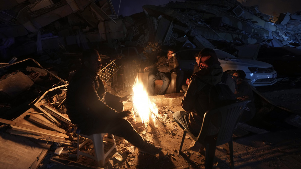 Szabadban rakott tűznél melegednek emberek a földrengés sújtotta dél-törökországi Hatay tartomány székhelyén, Antakyában 2023. február 8-án. A Törökországot és Szíriát február 6-án megrázó, 7,8-as erősségű földrengés és az utórengések halálos áldozatainak száma 15 ezer fölé emelkedett. A helyi hatóságok Törökországban már közel 63 ezer, Szíriában pedig 5 ezernél is több sérültről számoltak be.