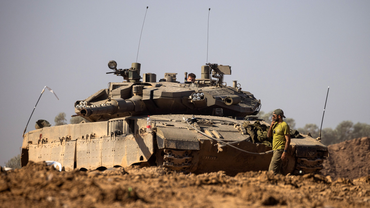 Izraeli katonák harckocsival egy dél-izraeli gyülekezési ponton, a Gázai övezet határának térségében 2023. november 24-én, miután életbe lépett a négynapos tűzszünet Izrael és a Gázai övezetet irányító Hamász palesztin iszlamista szervezet között. A Hamász fegyveresei október 7-én támadást indítottak Izrael ellen, az izraeli haderő pedig válaszul légi és szárazföldi hadműveleteket hajtott végre a Gázai övezetben.
