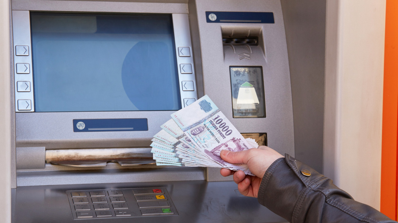 woman hand take out forint banknotes from atm