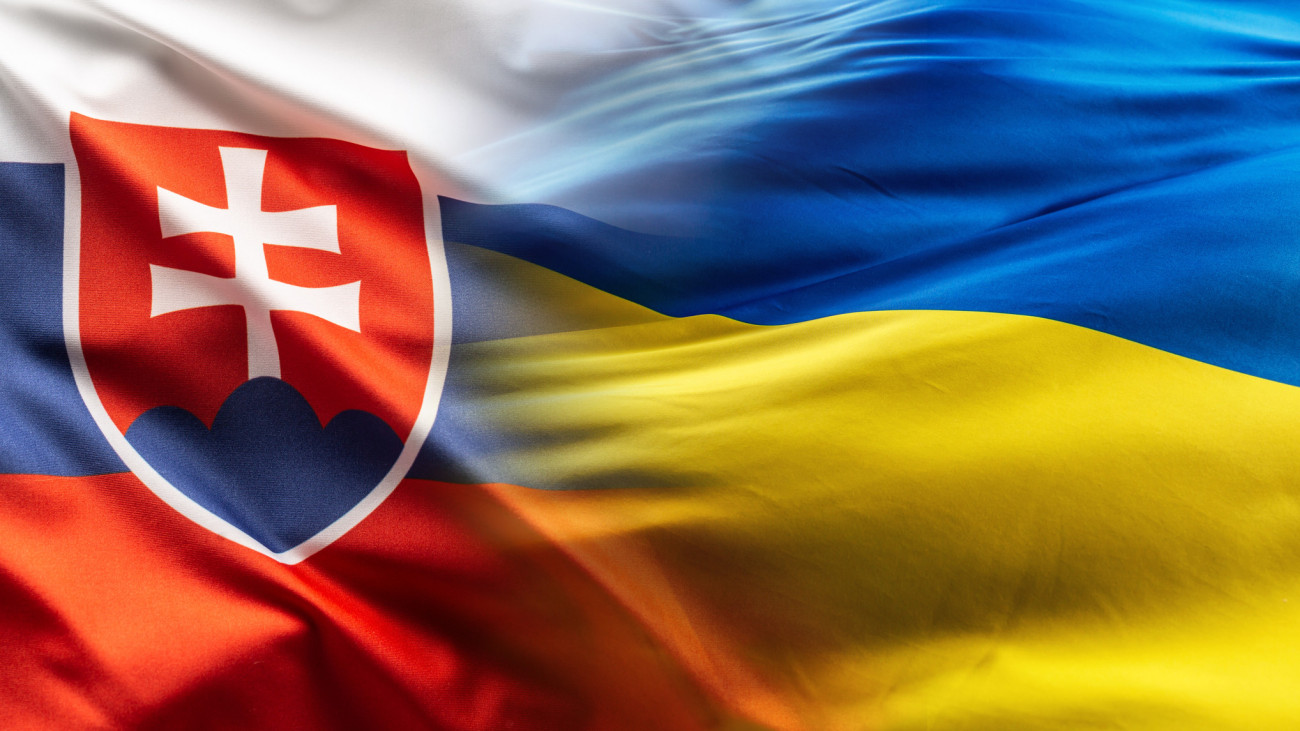 Slovak and Ukrainian flags flutter together in the wind.