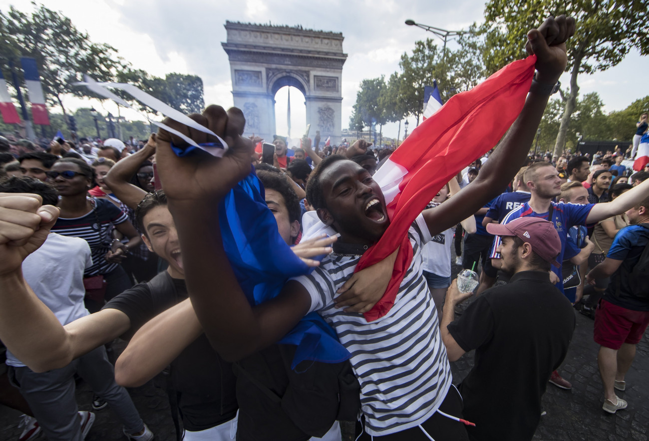 A francia válogatott diadalát ünnepli a tömeg a párizsi Champs-Élyées-n 2018. július 16-án. Franciaország az előző este 4-2-re győzött Horvátország ellen az oroszországi labdarúgó-világbajnokság döntőjében. A háttérben a diadalív látható. (MTI/EPA/Ian Langsdon)