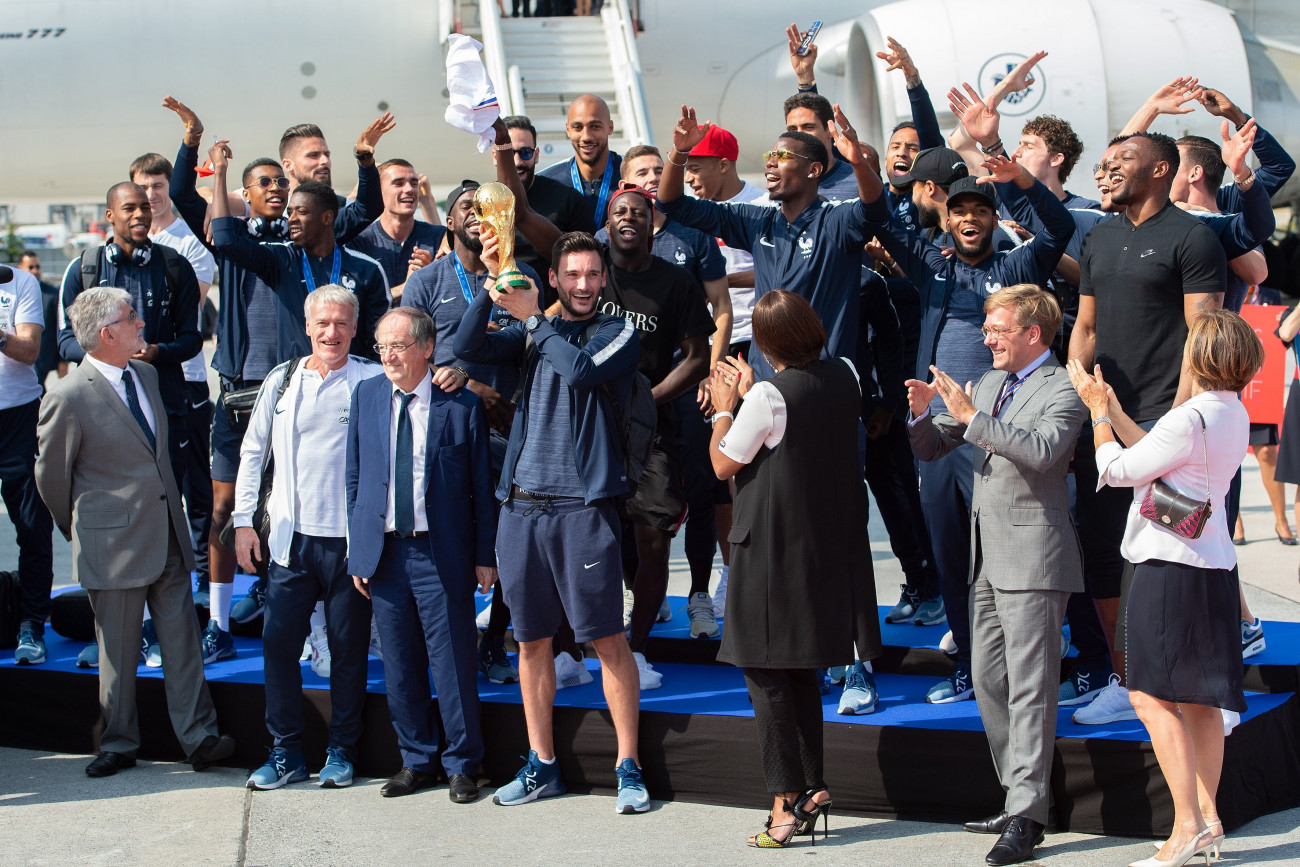 Didier Deschamps francia szövetségi kapitány (első sor, b2) és a világbajnok francia válogatott, miután megérkeztek a párizsi Charles de Gaulle nemzetközi repülőtérre 2018. július 16-án. Franciaország az előző este 4-2-re győzött Horvátország ellen az oroszországi labdarúgó-világbajnokság döntőjében. (MTI/EPA/Caroline Blumberg)