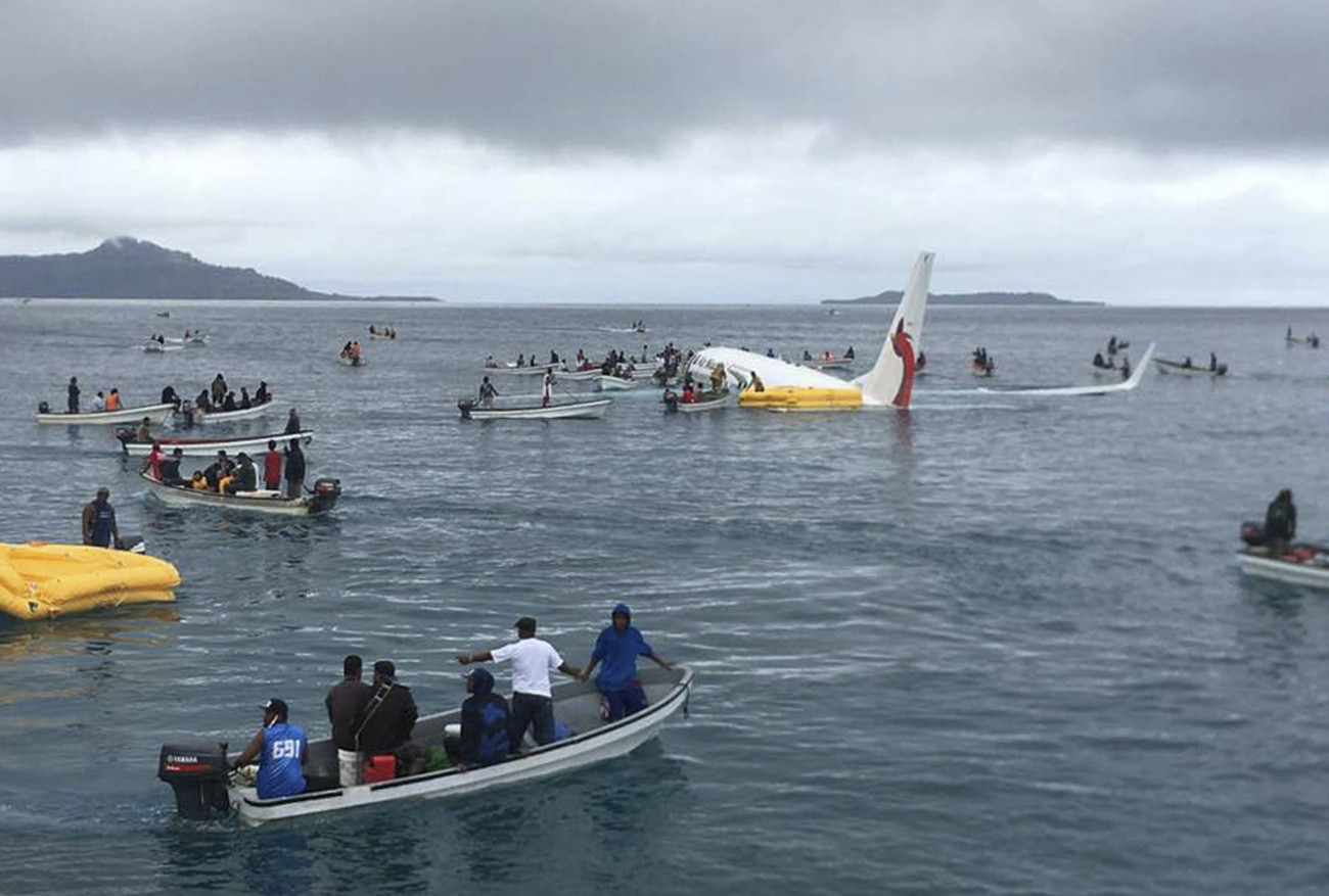 Chuuk, 2018. szeptember 28.
Halászcsónakok közelítenek meg egy utasszállító repülőgépet, amely túlfutott a kifutópályán és a tengerben állt meg a Mikronéziai Szövetségi Államokbeli Weno szigeten lévő Chuukban 2018. szeptember 28-án. Az Air Niuguni pápua új-guineai légitársaság Boeing 737-es típusú gépén utazó 36 utast és a 11 főnyi személyzetet csónakokkal kimentették. Senki nem szenvedett komolyabb sérülést.  (MTI/AP/James Yaingeluo)
