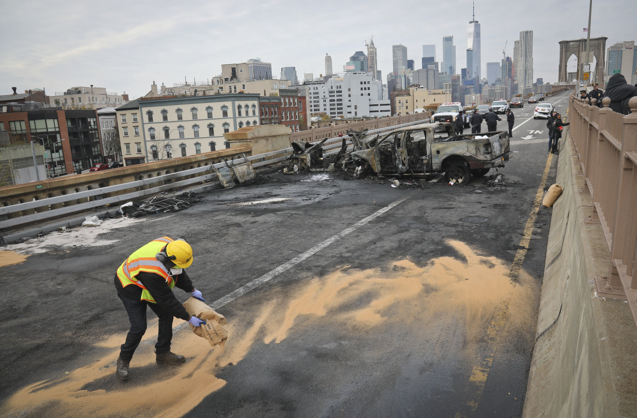 New York, 2018. november 21.
Homokot szór egy férfi a kiömlött üzemanyagra kiégett autók roncsaival a háttérben a Manhattan szigetét és New York Brooklyn nevű városrészét összekötő Brooklyn hídon 2018. november 21-én. A közúti balesetben egy ember életét vesztette, hatan megsérültek.
MTI/AP/Bebeto Matthews