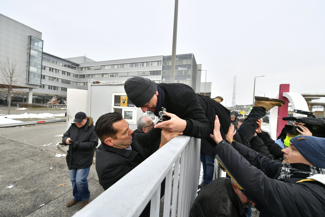Gréczy Zsolt, a DK-s országgyűlési képviselő átmászik a kerítésen az MTVA Kunigunda utcai székházának területére 2018. december 17-én. A területről Molnár Zsolt MSZP-s képviselő (b) segít neki. Ellenzéki képviselők az önkéntes túlmunka idő bővítéséről szóló törvény ellen demonstrálnak az MTVA székháza előtt és élő adásban szeretnék elmondani nyilatkozatukat.