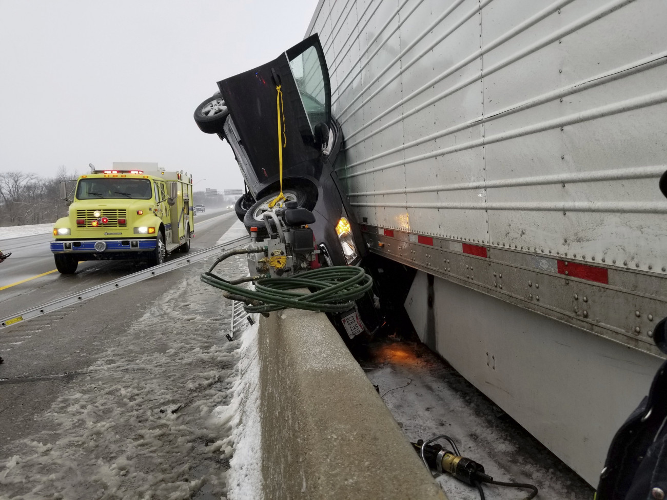 A Bethel Township-i tűzoltóság által közreadott képen egy kamion és egy betonkorlát közé szorult személyautó egy autópályán, az Ohio állambeli Mad River Township környékén 2019. február 10-én. A rossz idő miatt bekövetkezett balesetben senki sem sérült meg súlyosan.