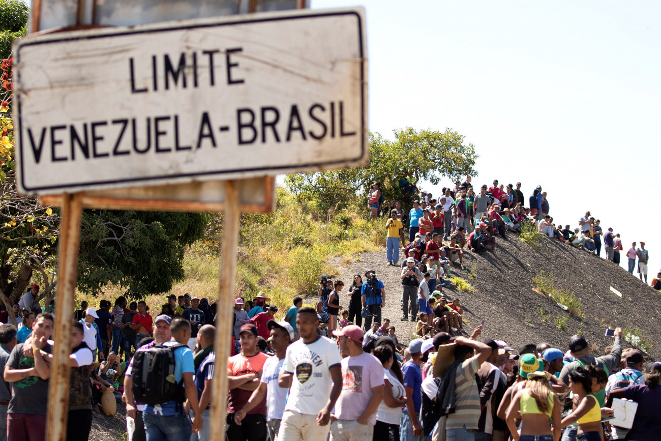 Pacaraima, 2019. február 23.
Venezuelai emberek a lezárt venezuelai-brazil határ venezuelai oldalán 2019. február 23-án, miután az első segélyszállítmány megérkezett a brazíliai Pacaraima városba.Nicolás Maduro venezuelai elnök elrendelte számos határátkelő lezárását, hogy megakadályozza az Egyesült Államokból Veneuzelába érkező segélyszállítmány bejuttatását az országba. Venezuelában hatalmi harc zajlik Maduro és a magát ideiglenes elnökké nyilvánító Juan Guaidó parlamenti elnök között. Guaidó, aki január 23-án kikiáltotta magát Venezuela ideiglenes elnökének, az Egyesült Államok és több más nyugati ország támogatását élvezi.
MTI/EPA/Joédson Alves