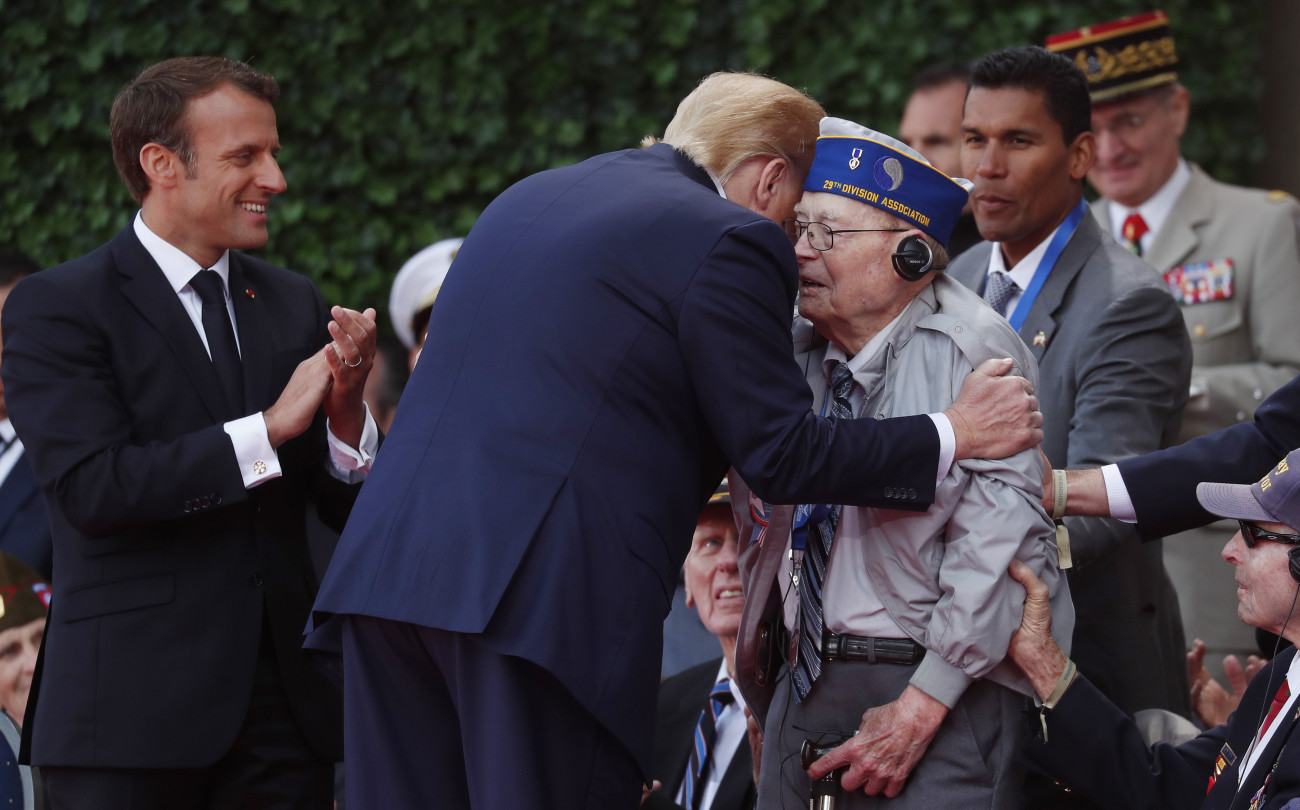 Colleville-sur-Mer, 2019. június 6.
Donald Trump amerikai elnök üdvözöl egy amerikai veteránt a normandiai partraszállás hetvenötödik évfordulója alkalmából tartott megemlékezésen a nyugat-franciaországi Colleville-sur-Merben 2019. június 6-án. Balról Emmanuel Macron francia államfő.
MTI/AP/Ian Langsdon