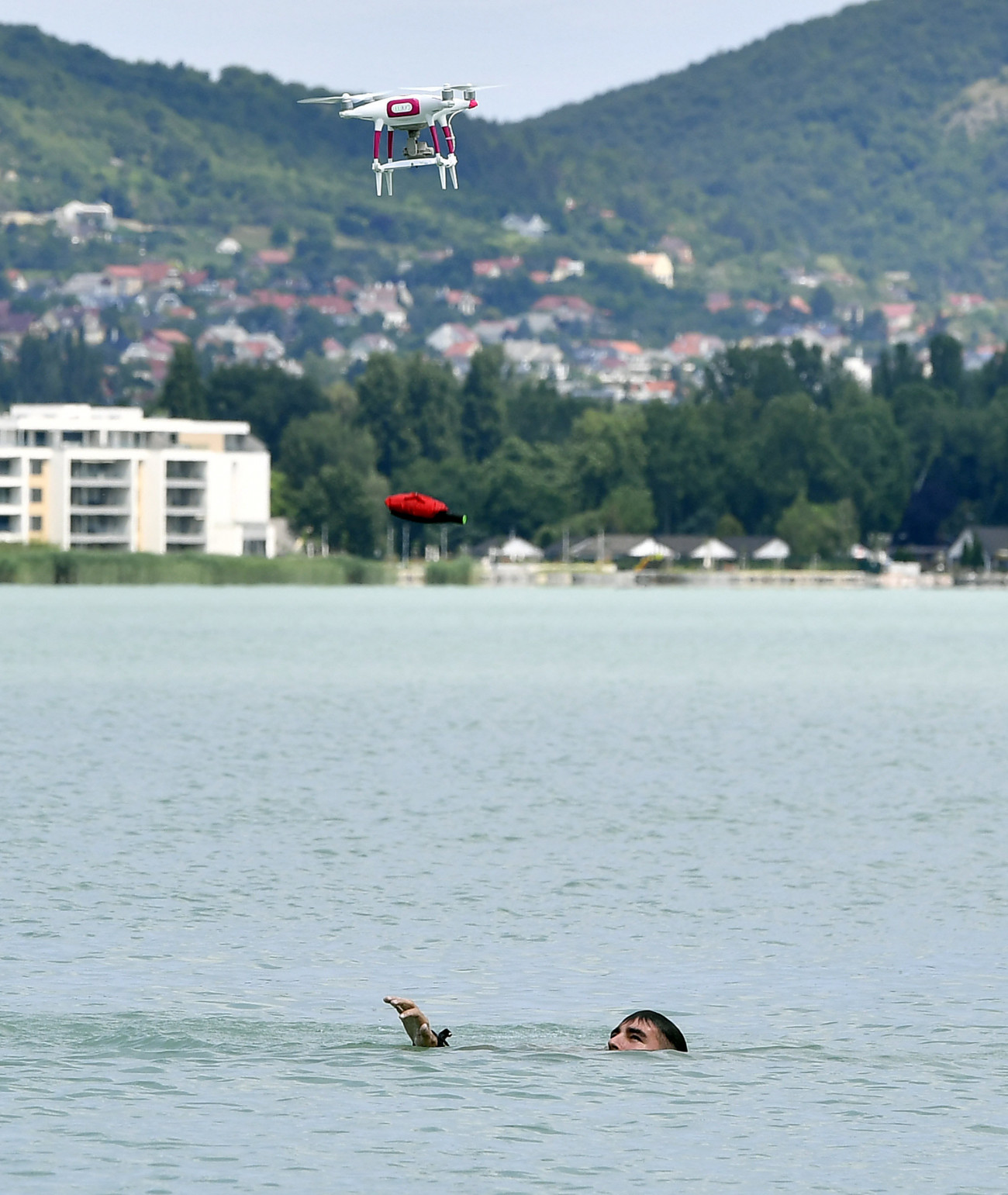 A vízimentők speciális szállító drónja egy vízben fölfújódó mentőpárnát dob le a mentési bemutatón Tihanynál 2019. június 21-én.
MTI/Máthé Zoltán