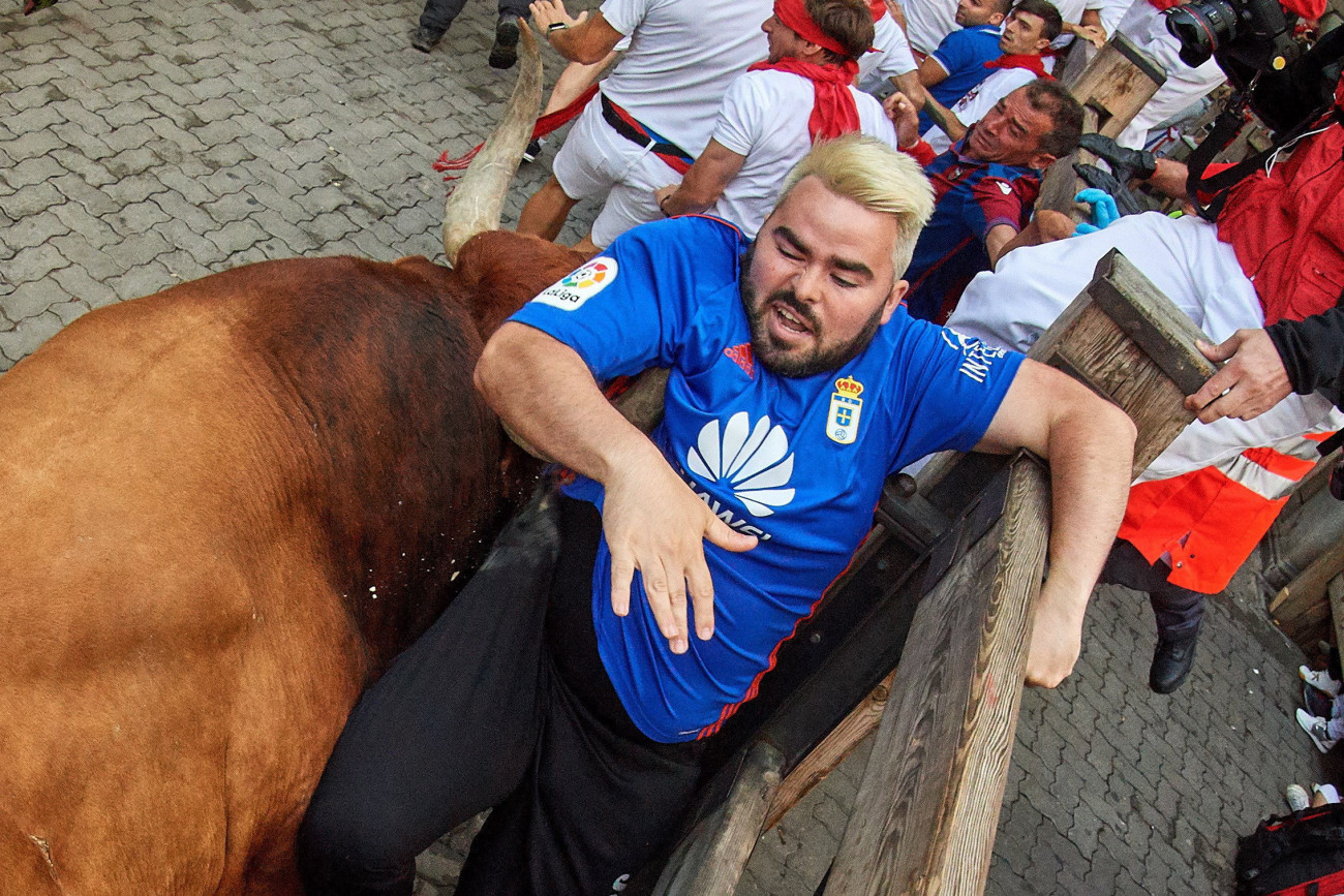 A védőkorláthoz szorítja szarvával a bika az egyik futót a San Fermín fesztiválon Pamplonában 2019. július 14-én. A spanyol város védőszentjének tiszteletére 1591 óta évente megrendezett kilencnapos fiesta egyik fő attrakciója a reggelenkénti bikafuttatás, amelynek során férfiak százai teszik próbára bátorságukat azzal, hogy az arénába hajtott állatok előtt végigszaladnak Pamplona utcáin.
MTI/EPA/Daniel Fernandez