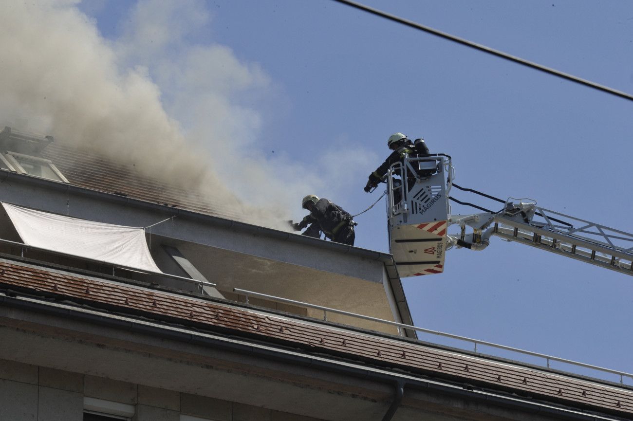 Tűzoltók a Soroksári úton, ahol tűz ütött ki egy hétemeletes lakóépület tetején 2019. augusztus 19-én.
MTI/Mihádák Zoltán