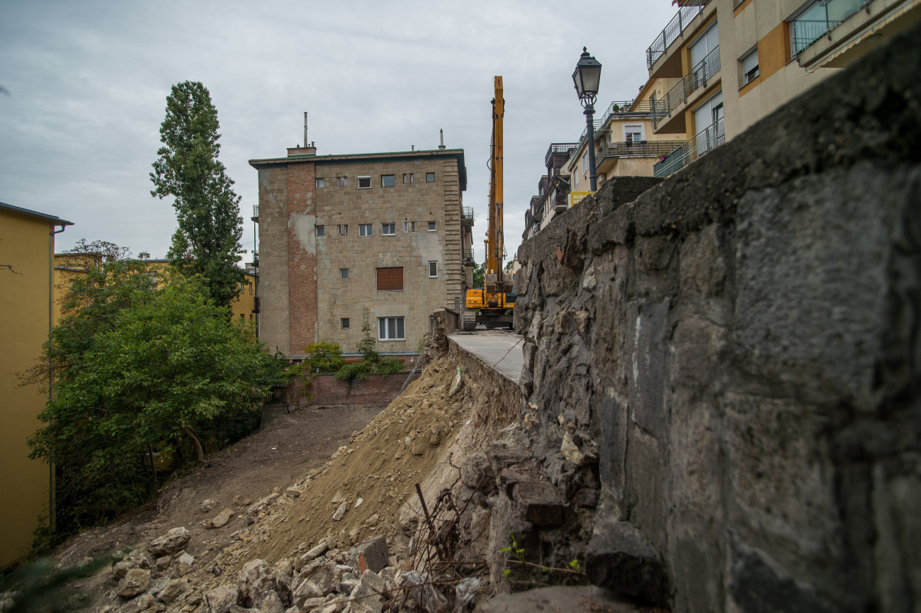Budapest, 2019. szeptember 17.
Az előző napon beomlott támfal az I. kerületi Logodi utcában 2019. szeptember 17-én. A Budavári Önkormányzat tájékoztatása szerint a Logodi utca 56-58. szám alatti, magántulajdonban lévő építési telek a világörökség része és régészetileg védett. A helyszínen tartott sajtótájékoztatón közölték: szabálytalan és engedély nélküli építési munka vezetett a támfalomláshoz.
MTI/Balogh Zoltán