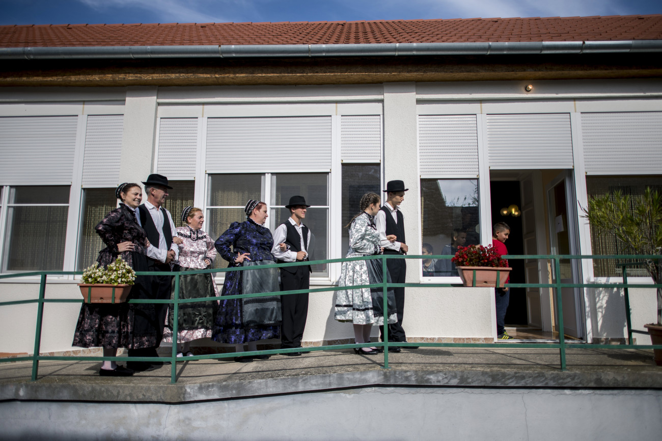 Újpetrei hagyományos Duna menti német népviseletbe öltözött szavazók érkeznek Újpetrén a helyi önkormányzati képviselők és polgármesterek, valamint a nemzetiségi önkormányzati képviselők választásán 2019. október 13-án.
MTI/Sóki Tamás