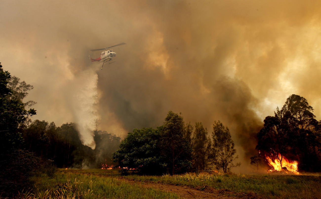 Old Bar, 2019. november 9.
Helikopterről ledobott tűzgátló anyaggal próbálják megfékezni a lángokat az Új-Dél-Wales állambeli Old Bar település közelében 2019. november 9-én. Új-Dél-Walesben 72 bozóttűz volt aktív, ezek közül 18-at egyelőre nem tudtak megfékezni, és hat veszélyeztet lakott területet. Az államban legkevesebb két ember életét vesztette, több százezer hektárnyi terület égett le.
MTI/EPA/AAP/Darren Pateman
