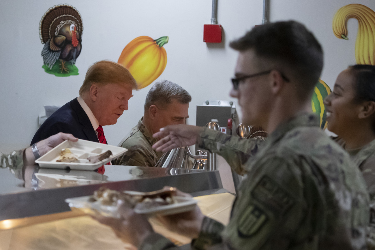 Donald Trump amerikai elnök (b) Mark Milley tábornoknak, a vezérkari főnökök egysített bizottsága elnökének (b2) társaságában vacsorát oszt a bagrami légi támaszponton szolgáló amerikai katonáknak, akiket a hálaadás ünnepének alkalmából keresett fel meglepetésszerű afganisztáni látogatása alatt, 2019. november 28-án. MTI/AP/Alex Brandon