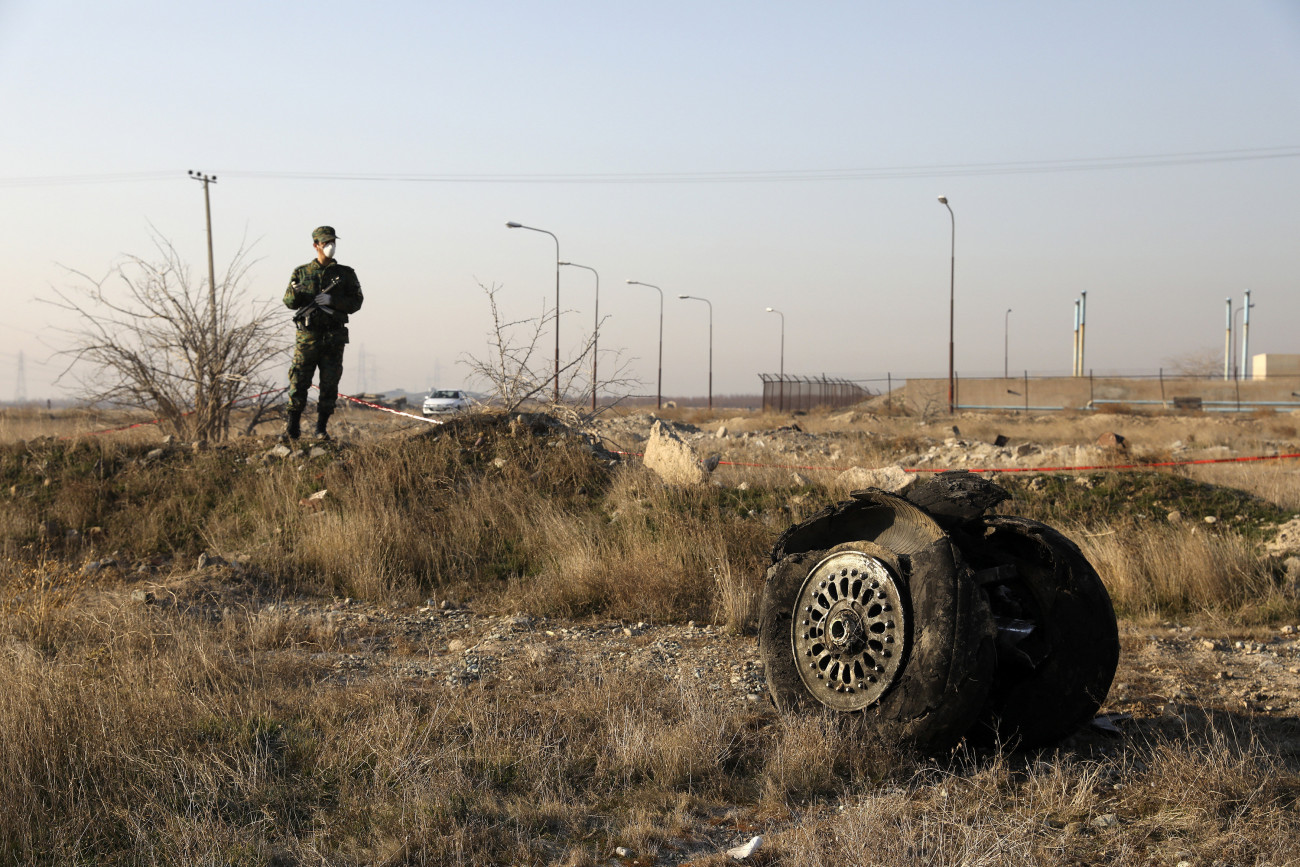 Sahriár, 2020. január 8.
Rendőr áll a lezuhant Boeing 737-es típusú ukrán utasszállító repülőgép egyik kerekénél a baleset helyszínén, az iráni Sahriár város közelében 2020. január 8-án. A légi jármű hajnalban zuhant le 167 utassal és 9 fős személyzettel a fedélzetén, kevéssel a teheráni Khomeini Imám repülőtérről történt felszállás után. A szerencsétlenséget senki sem élte túl.
MTI/AP/Ibrahim Norúzi