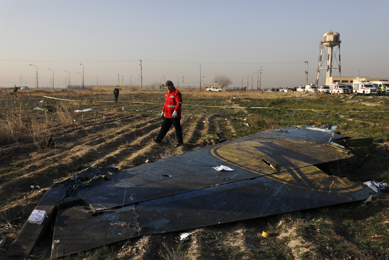 Sahriár, 2020. január 8.
A mentőegység tagja a lezuhant Boeing 737-es típusú ukrán utasszállító repülőgép egyik szárnyvégénél a baleset helyszínén, az iráni Sahriár város közelében 2020. január 8-án. A légi jármű hajnalban zuhant le 167 utassal és 9 fős személyzettel a fedélzetén, kevéssel a teheráni Khomeini Imám repülőtérről történt felszállás után. A szerencsétlenséget senki sem élte túl.
MTI/AP/Ibrahim Norúzi