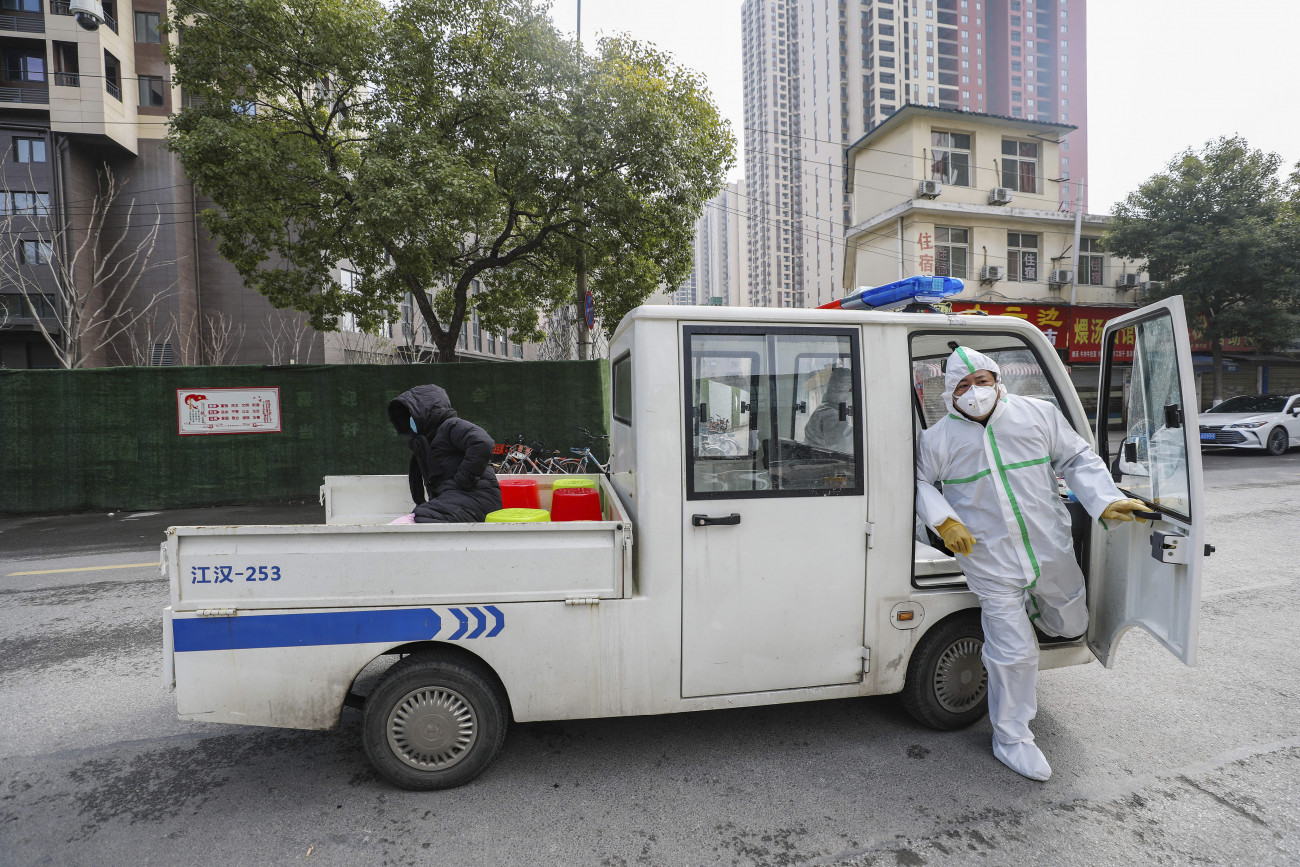 Fertőzésgyanús személyt szállít egy védőöltözetet viselő kormányzati alkalmazott egy vuhani kórházba. Fotó: MTI/AP/Chinatopix