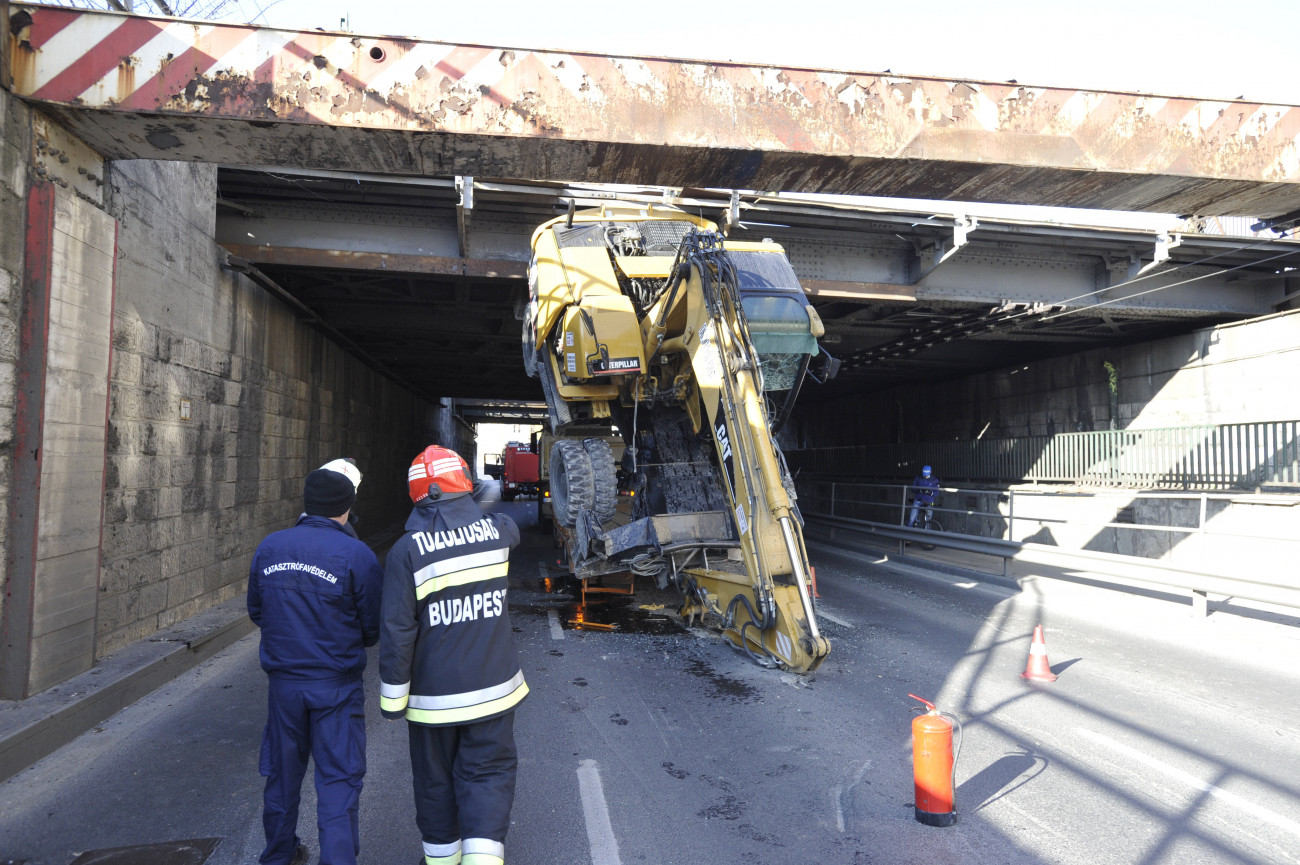 Budapest, 2020. április 1.
A kőbányai vasúti felüljáró alá szorult, munkagépet szállító teherautó műszaki mentésén dolgoznak a tűzoltók 2020. április 1-jén. A baleset a Könyves Kálmán körúton, az Árpád híd felé vezető oldalon történt.
MTI/Mihádák Zoltán