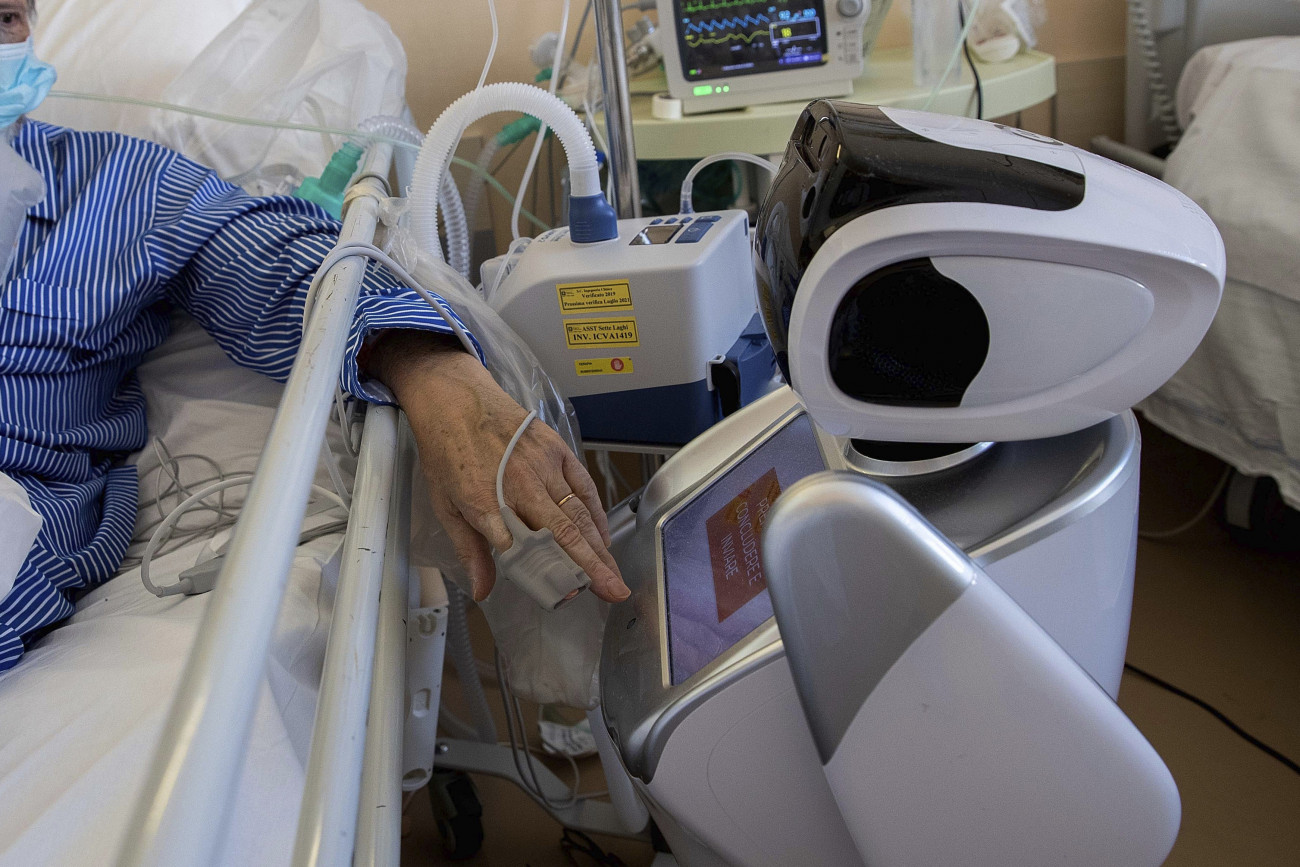 Varese, 2020. április 8.
Koronavírussal fertőzött beteg egy robottal kommunikál az olaszországi Varese egyik kórházának intenzív osztályán 2020. április 8-án. Hat robot segíti az egészségügyi dolgozók munkáját.
MTI/AP/Luca Bruno