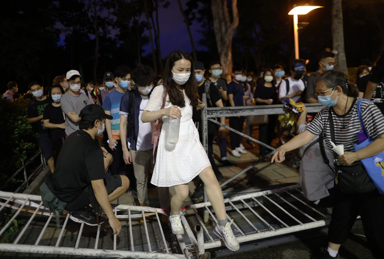 Hongkong, 2020. június 4.
A hatóságok tiltása ellenére a pekingi Tienanmen téri mészárlás áldozatairól megemlékező emberek átlépnek egy felállított fémkordonon Hongkongban 2020. június 4-én, a demokratikus változásokat követelő kínai diákmozgalom vérbe fojtásának 31. évfordulóján. A Kínai Néphadsereg 1989. június 4-én megtámadta a pekingi Tienanmen téren hat héten át tüntető több tízezer diákot, és kíméletlen, sok halottat követelő beavatkozással véget vetett  tüntetéssorozatnak.
MTI/EPA/Jerome Favre