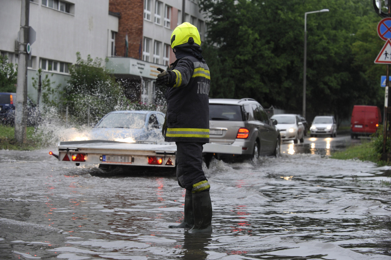 Budapest, 2020. június 14.
Tűzoltó irányítja a vihar után összegyűlt esővízben haladó járműveket a főváros X. kerületében, a Maglódi út és a Gitár utca kereszteződésénél 2020. június 14-én.
MTI/Mihádák Zoltán