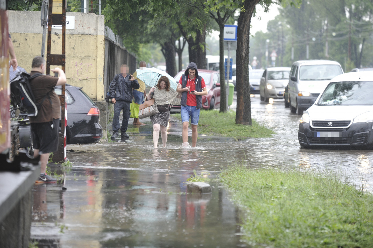 Budapest, 2020. június 18.
Gyalogosok mennek a vihar után összegyűlt esővízben a főváros X. kerületében, a Maglódi út és a Gitár utca kereszteződésében 2020. június 18-án.
MTI/Mihádák Zoltán