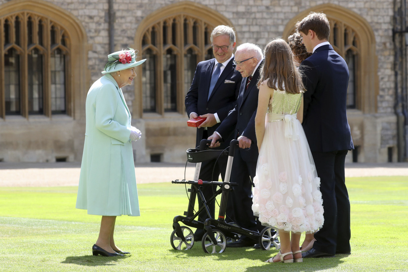 Windsor, 2020. július 17.
II. Erzsébet brit uralkodó (b) Tom Moore kapitánnyal, a II. világháborús veteránnal (j) és családjával beszélget a windsori kastély kertjében, miután lovagi rangra emelte az idős férfit egy ceremónia keretében az angliai Windsorban 2020. július 17-én. Az idős férfi áprilisban járókeretével több száz kört tett meg kertjében, célja eredetileg az volt, hogy akciójával ezer fontot összegyűjtsön és ezzel köszönje meg az egészségügyi dolgozók áldozatos munkáját a koronavírus-járvány idején.
MTI/AP/GETTY pool/Chris Jackson