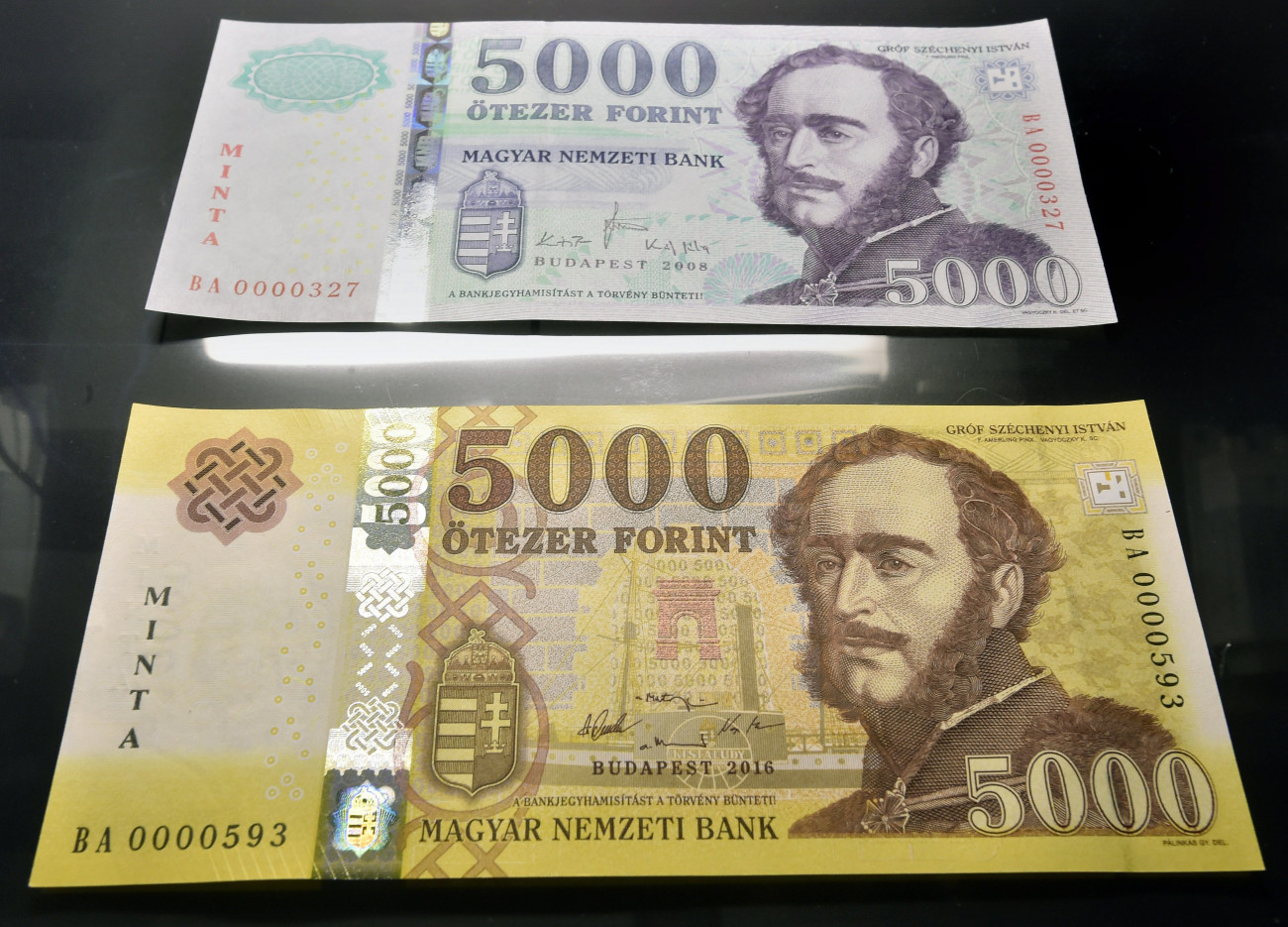 Budapest, 2016. november 14.
Az új 5000 forintos bankjegy mintája (alul) az azonos címletű jelenlegi bankjegy mellett a Magyar Nemzeti Bank (MNB) fővárosi székházában tartott sajtótájékoztatón 2016. november 14-én. Megújulnak a 2000 és az 5000 forintos címletű bankjegyek, az új bankók november 15-étől válnak törvényes fizetőeszközzé, de a készpénzforgalomban csak 2017. március 1-jétől lehet találkozni velük. A jelenlegi bankjegyek 2017. július 31-ig maradnak a készpénzforgalomban.
MTI Fotó: Máthé Zoltán