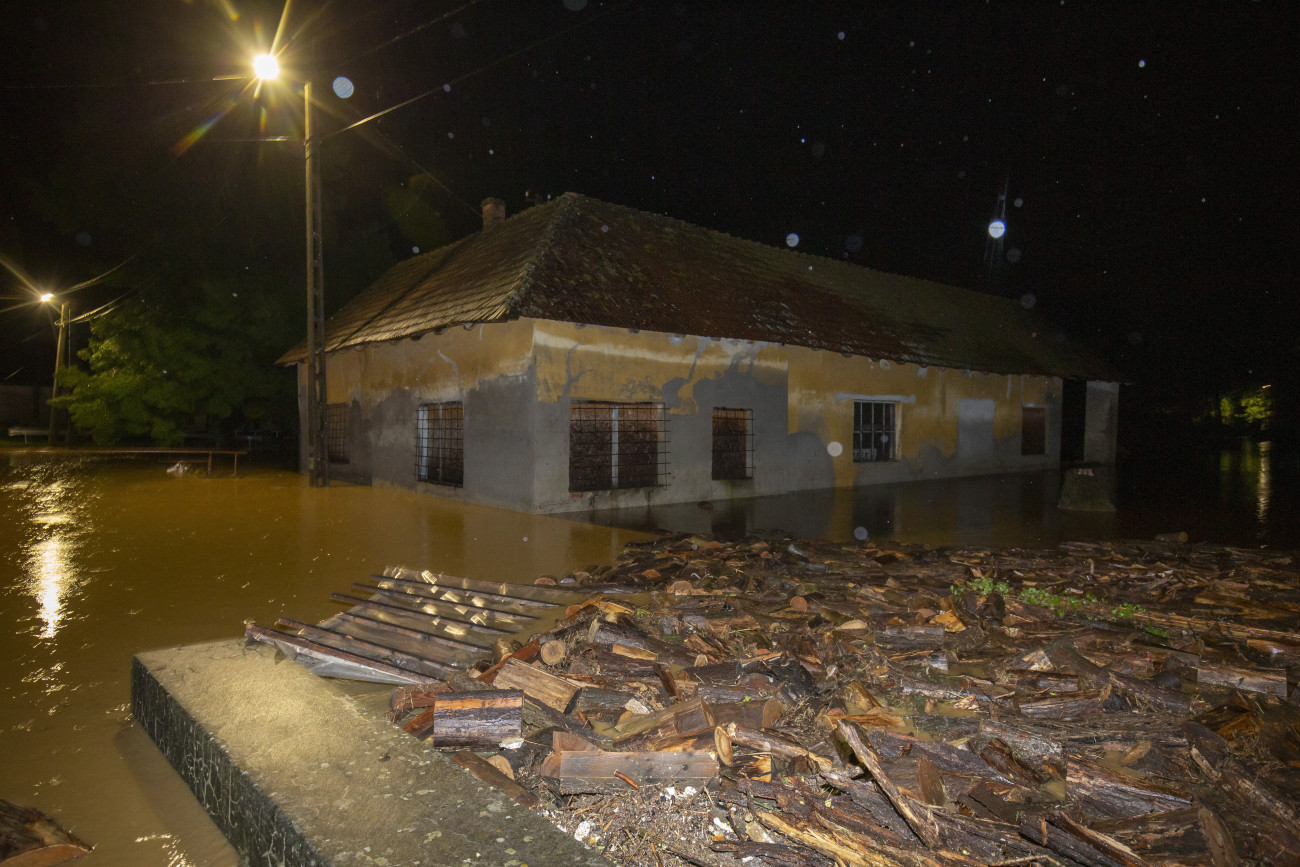 A nagy esőzés miatt vízzel körülvett ház a Zala megyei Surdon 2020. július 24-én éjjel. A térségen átvonuló vihar következtében a domboldalakról lezúduló nagy mennyiségű esővíz több településen elárasztotta az alacsonyabban fekvő részeket.
MTI/Varga György