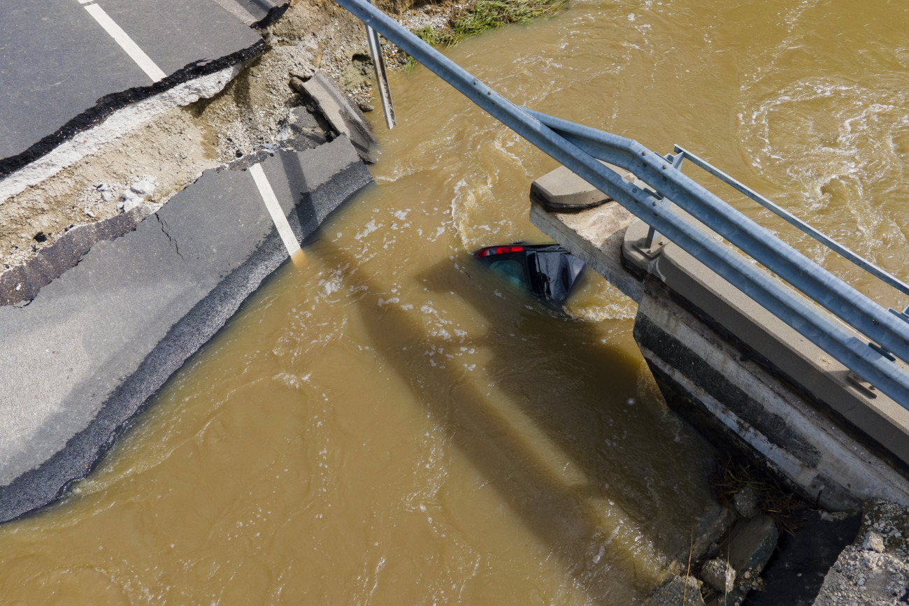 Nagyatád, 2020. július 26.
Személygépkocsi a vízben a heves esőzés miatt megáradt Rinya-patak leszakadt hídjánál a 68-as főút Nagyatádot elkerülő szakaszán 2020. július 26-án.
MTI/Varga György