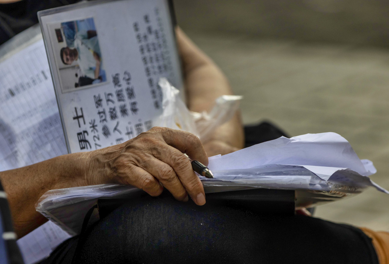 Sanghaj, 2020. augusztus 12.
Egyedül álló hozzátartozója személyes adatait ismertető táblát tart a kezében egy nő a sanghaji házassági piacon 2020. augusztus 9-én. A kínai város Népek parkjában minden szombaton és vasárnap összegyűlnek a hajadon férfiak és nők szülei, hogy a gyermeküknek párt találjanak. A papírlapokra felírják a férjet vagy feleséget keresők legfontosabb adatait: a kort, a magasságot, a fizetést, az iskolázottságot, a kínai horoszkóp jelet, illetve, hogy a jelöltnek van-e kocsija és saját lakása. A szülők körbejárnak és felmérik a kínálatot, hogy megtalálják a gyerekükhöz szerintük méltó társat. A párválasztást nem hivatalosan működő ügynökök is segíteni próbálják.
MTI/EPA/Alex Plavevski