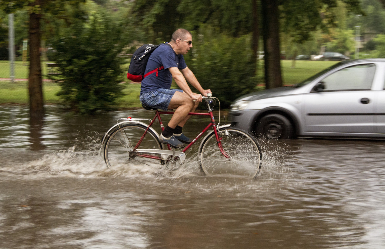 Győr, 2020. augusztus 17.
Kerékpáros halad a heves zápor után esővízzel borított győri Bem téren 2020. augusztus 17-én.
MTI/Krizsán Csaba