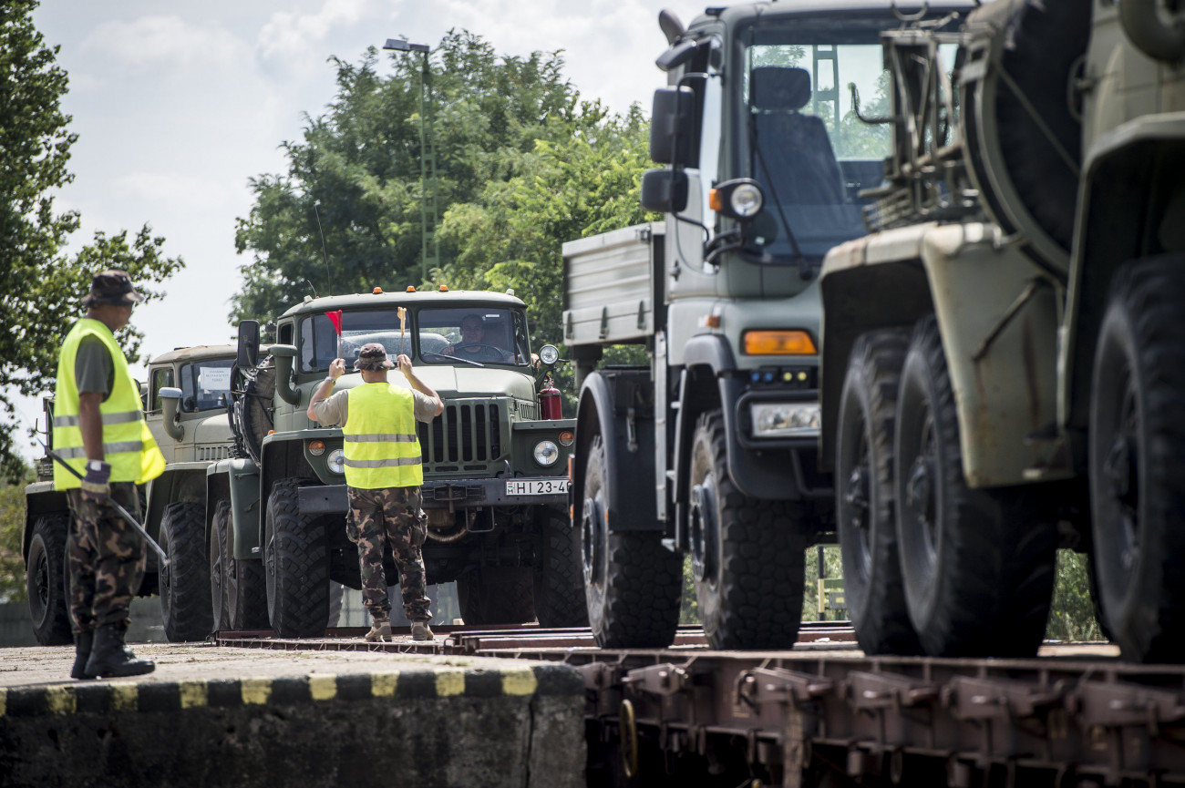 Kecskemét, 2020. augusztus 24.
Vasúti kocsikra rakják és elszállítják az üzemképtelen, elavult vagy nem javítható technikai eszközöket, köztük teherautókat a kecskeméti repülőbázisról 2020. augusztus 24-én.
MTI/Ujvári Sándor