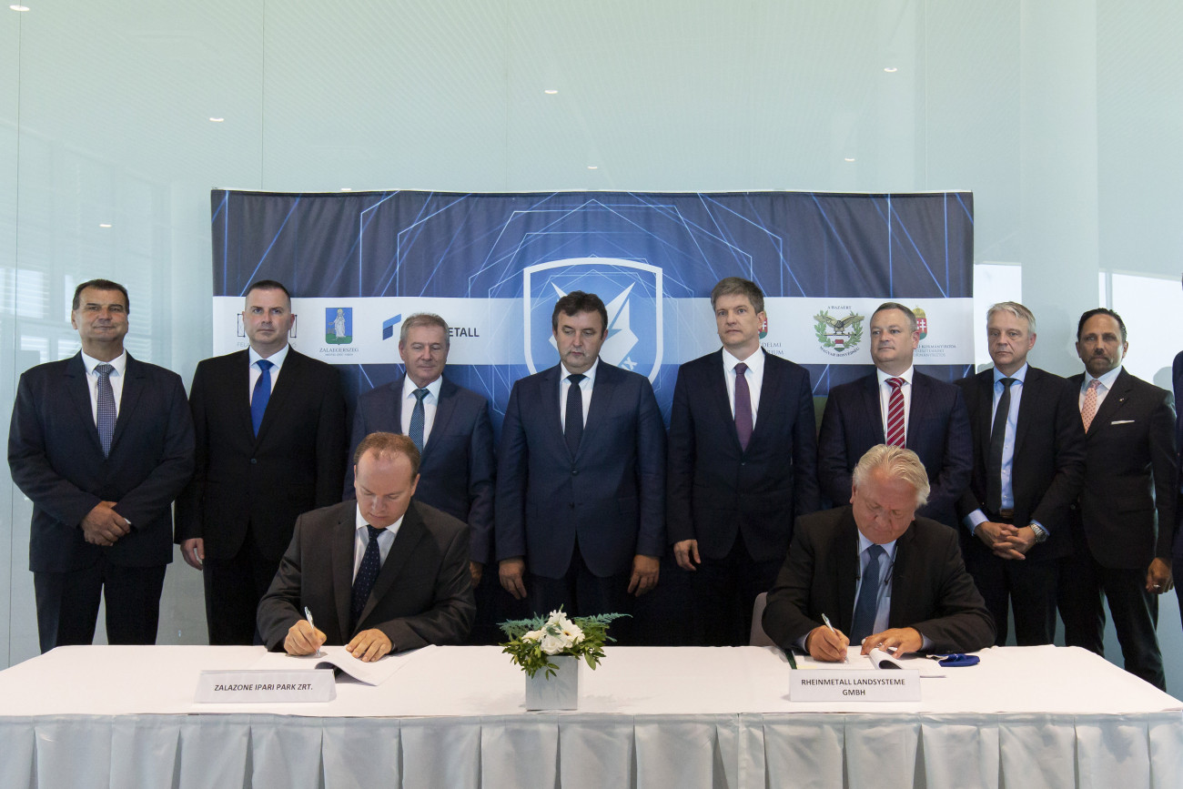 Budapest, 2020. szeptember 10.
Háry András, a ZalaZone ügyvezető igazgatója (b) és Armin Papperger, a Rheinmetall AG igazgatótanácsának elnöke aláírja az együttműködési megállapodást a mintegy 60 milliárd forintos beruházással megépülő, harcjárműveket gyártó üzem építésének bejelentésén Zalaegerszegen, a ZalaZone Járműipari Tesztpálya fogadóépületében 2020. szeptember 10-én. Mögöttük Palkovics László innovációs és technológiai miniszter (b4), Benkő Tibor honvédelmi miniszter (b3), Balaicz Zoltán (Fidesz-KDNP), Zalaegerszeg polgármestere (b2), Vigh László, Zalaegerszeg fideszes országgyűlési képviselője (b), Maróth Gáspár, a Miniszterelnökség védelmi fejlesztésekért felelős kormánybiztosa (j4), John Joseph Abunassar, a Rheinmetall igazgatója (j3), Andreas Baumeier, a Rheinmetall meghatalmazott aláírója (j2) és Oliver Mittelsdorf, a Rheinmetall Landsysteme lánctalpas járművek és tornyok értékesítési alelnöke (j).
MTI/Varga György