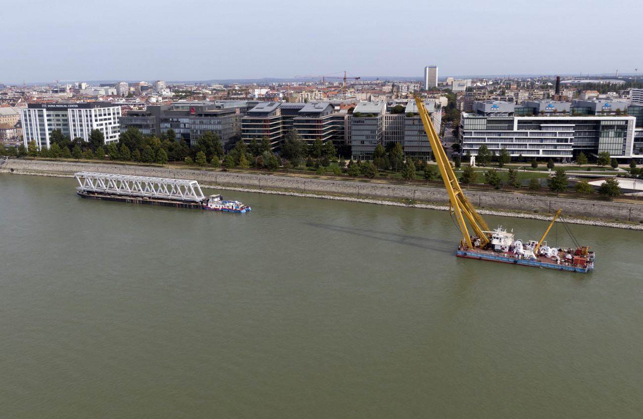 Budapest, 2020. szeptember 16.
A felújítás és átépítés alatt álló déli összekötő vasúti híd egyik elemét szállító bárka, valamint a Clark Ádám úszódaru a Dunán 2020. szeptember 16-án.
MTI/Máthé Zoltán