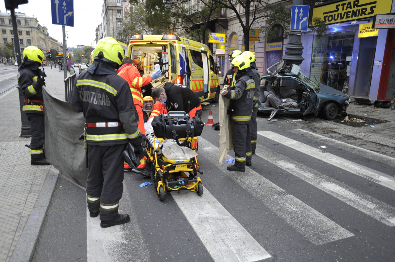 Budapest, 2020. november 1.
Mentősök látják el az egyik sérültet a Károly körúton történt baleset helyszínén 2020. november 1-jén, ahol egy autó villanyoszlopnak csapódott. Az autót vezető 17 éves fiú a helyszínen életét vesztette, utasát életveszélyes sérülésekkel szállították kórházba.
MTI/Mihádák Zoltán