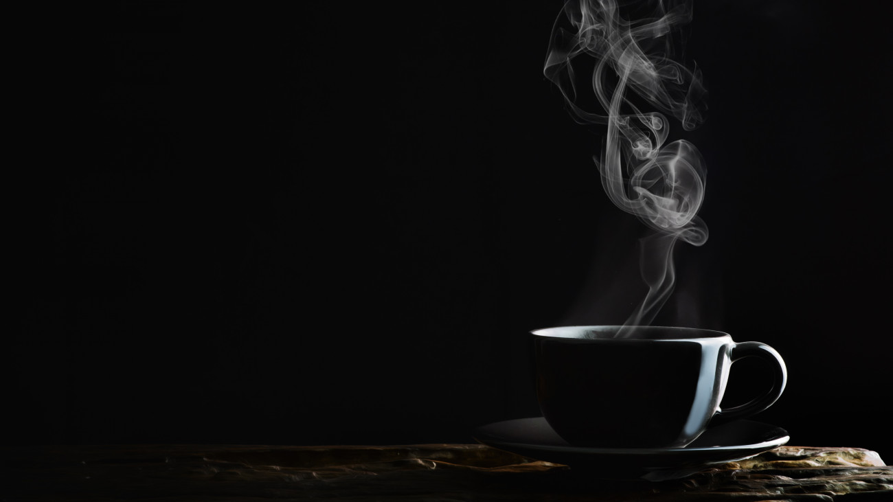 beverage background of hot coffee, tea or chocolate in black cup on wooden plank in dark background