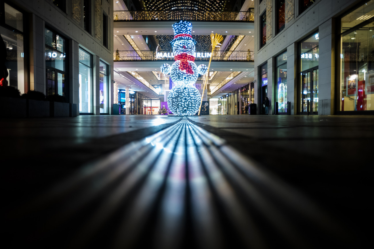 Berlin, 2020. december 16.
Kivilágított hóember a Mall of Berlin bevásárlóközpont bejáratánál 2020. december 16-án. Németországban ismét rekordot döntött és megközelítette az ezret a koronavírus-járvány halálos áldozatainak napi száma. December 16-tól legalább január 10-ig csak a mindennapi élethez elengedhetetlen cikkeket árusító boltok tarthatnak nyitva, ugyancsak a létfenntartáshoz szükséges minimumra korlátozták a szolgáltatásokat, az iskolákban, óvodákban ügyeleti rendszert vezettek be, és felkérték a munkaadókat, hogy a lehető legszélesebb körben tegyék lehetővé az otthoni munkavégzést.
MTI/AP/Markus Schreiber