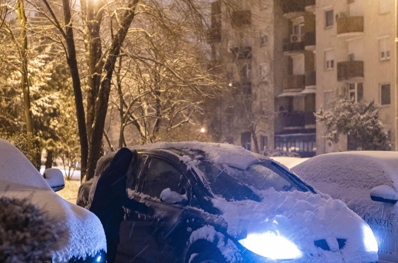 Nyíregyháza, 2021. január 13.
Letakarítja a havat autójáról egy nő a nyíregyházi Dohány utcában 2021. január 13-án.
MTI/Balázs Attila