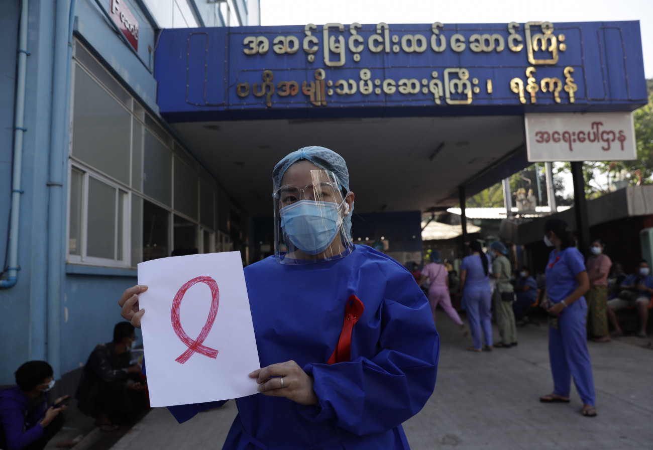 Rangun, 2021. február 3.
Piros szalagot visel védőruházatán egy egészségügyi dolgozó az előző napokban végrehajtott katonai hatalomátvétel elleni tiltakozás jeléül a ranguni Központi Női Kórház előtt 2021. február 3-án. Egy civil engedetlenségi mozgalom Facebookon közzétett bejelentése szerint Mianmarban hetven kórház egészségügyi személyzete lépett sztrájkba, mert véleményük szerint a katonaság saját érdekeit a koronavírus-járvánnyal küzdő emberek érdekei elé helyezi.
MTI/EPA/Lynn Bo Bo