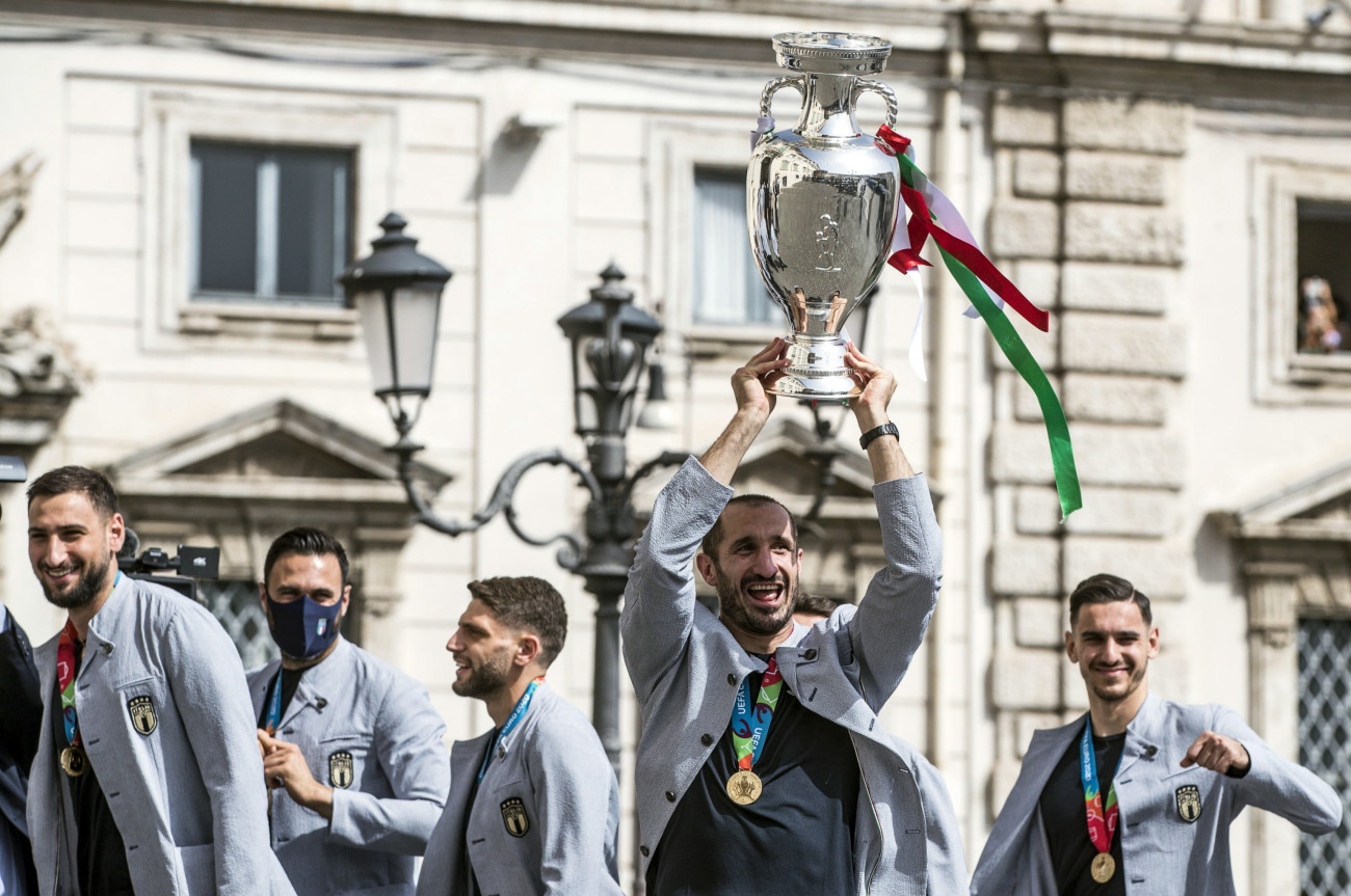Róma, 2021. július 12.
Giorgio Chiellini, az olasz labdarúgó-válogatott csapatkapitánya (j2) a bajnoki trófeával megérkezik a római Quirinale elnöki palotába, ahol Sergio Mattarella olasz államfő fogadja a csapatot 2021. július 12-én, egy nappal azután, hogy megnyerték a koronavírus-járvány miatt 2021-re halasztott 2020-as labdarúgó Európa-bajnokság döntőjében játszott Olaszország-Anglia mérkőzést. Olaszország az 1-1-es döntetlennel zárult rendes játékidőt követő hosszabbítás utáni büntetőpárbajban 3-2-re győzött, és 1968 után másodszor lett a kontinens legjobbja.
MTI/EPA/ANSA/Angelo Carconi