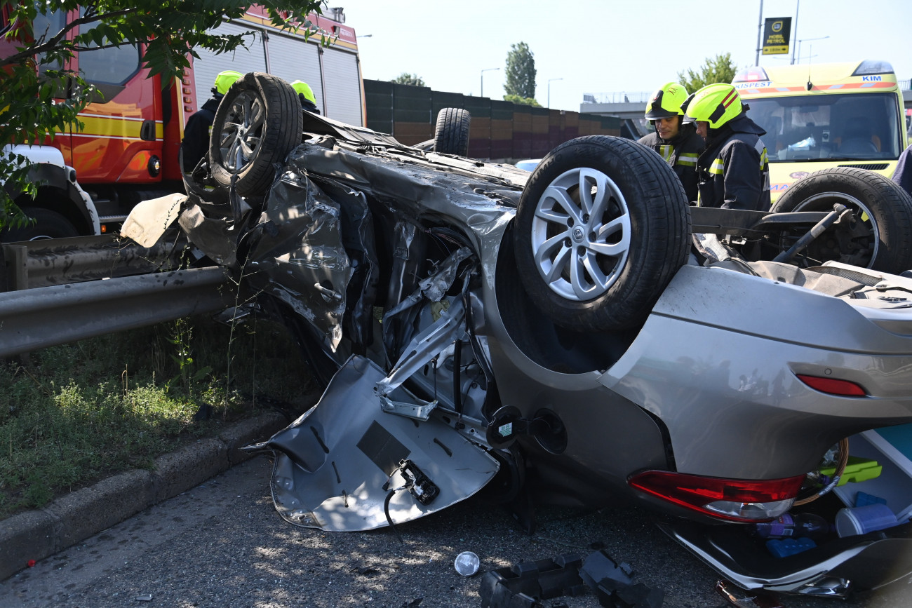 Budapest, 2021. július 18.
Tűzoltók és mentőautó az összeroncsolódott személyautó mellett a főváros XIX. kerületében, a Nagykőrösi úton, ahol a gépjármű szalagkorlátnak ütközött, majd felborult 2021. július 18-án. A balesetben két személy megsérült.
MTI/Mihádák Zoltán