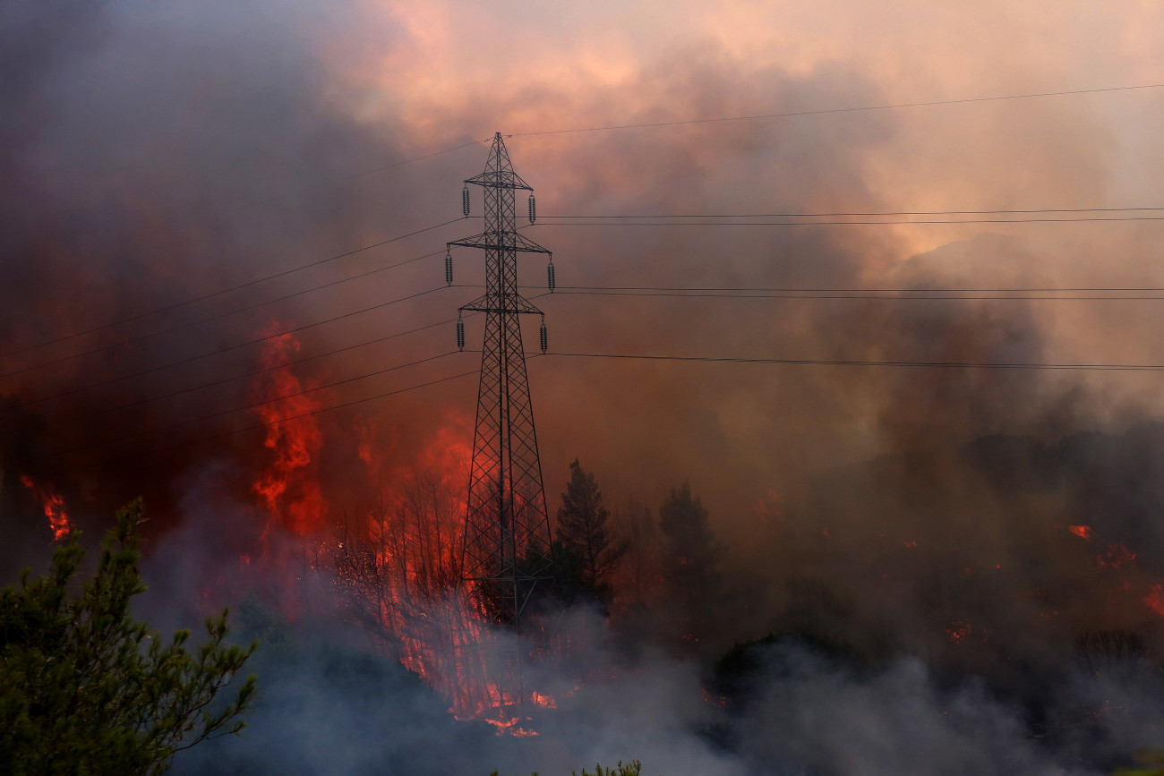 Varibobi, 2021. augusztus 3.
Lángol a növényzet Athén északkeleti külvárosa, Varibobi környékén 2021. augusztus 3-án. 350 tűzoltó, 70 járművel, öt helikopterrel és kilenc repülővel próbálja oltani a tüzet, amely egyelőre nem fenyeget lakóépületeket, ipari létesítményeket, de vastag füstfelhővel borítja be a város légterének egy részét. Görögországban, ahol 42 Celsius-fokos hőség tombol, több mint száz helyen kapott lángra a növényzet az utóbbi napokban.
MTI/EPA/ANA-MPA/Oresztisz Panajotu
