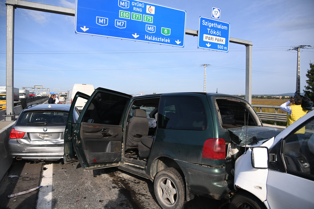 Szigetszentmiklós, 2021. szeptember 2.
Összetört autók az M0-s autóút 18-as kilométerénél, a szigetszentmiklósi csomópont közelében 2021. szeptember 2-án. A három karambolozó jármű közül kettőt román állampolgár vezetett, akik határsértőket szállítottak. A baleset helyszínén elfogtak tizenegy, magát iraki és szír állampolgárnak valló férfit, a sofőrrel együtt előállítják őket. A határsértőket  meghallgatásuk után - visszakísérik a biztonsági határzárhoz, a két román sofőr ellen embercsempészés bűntettének gyanúja miatt büntetőeljárás indul.
MTI/Mihádák Zoltán