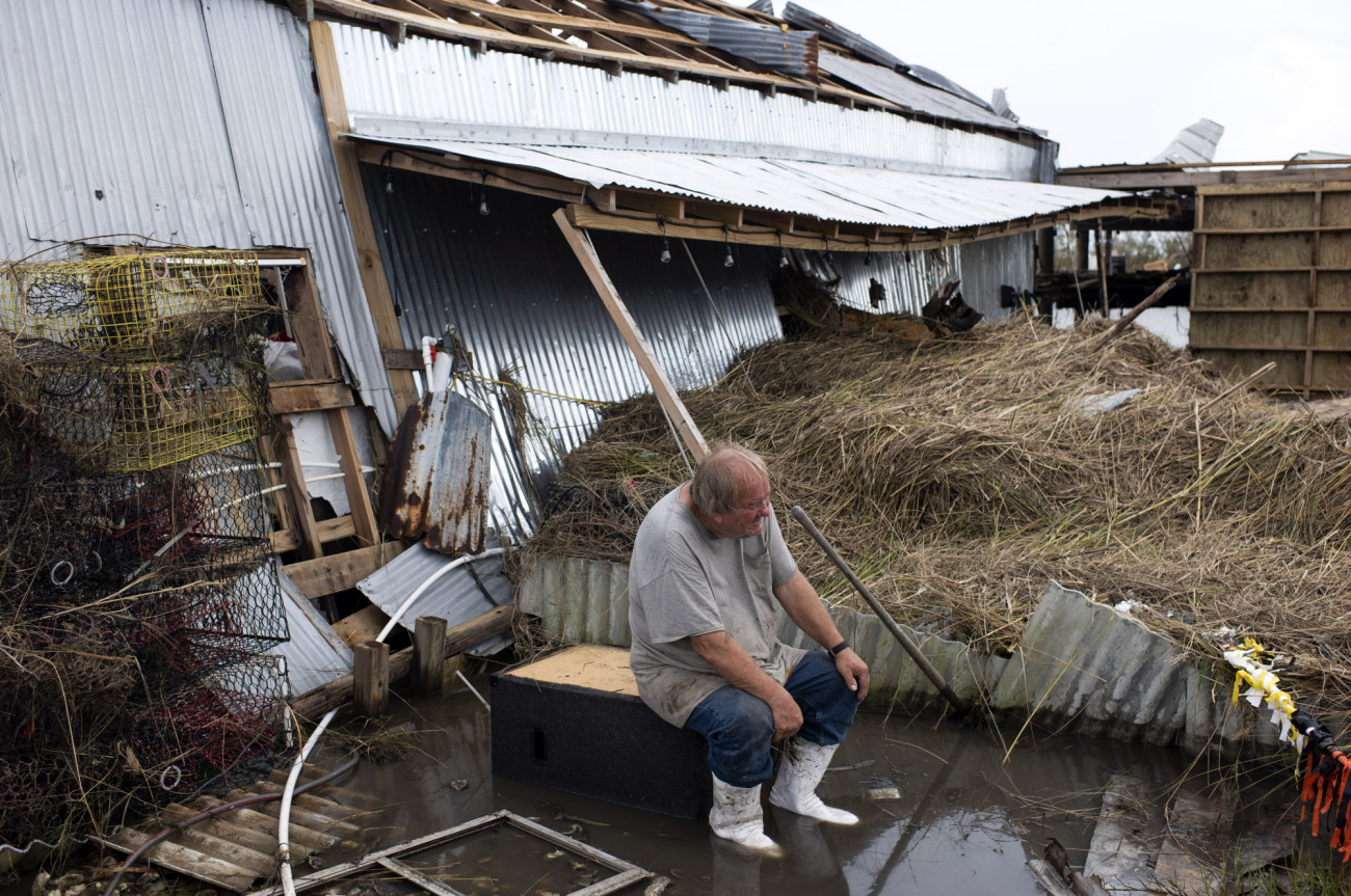 A residents watches as debris is cleared from his boat dock after Hurricane Ida in Cocodrie, Louisiana, U.S., on Wednesday, Sept. 1, 2021. The electric utility that serves New Orleans has restoredÂ powerÂ to a small section of the city after HurricaneÂ Ida devastated the region's grid. Photographer: Mark Felix/Bloomberg via Getty Images