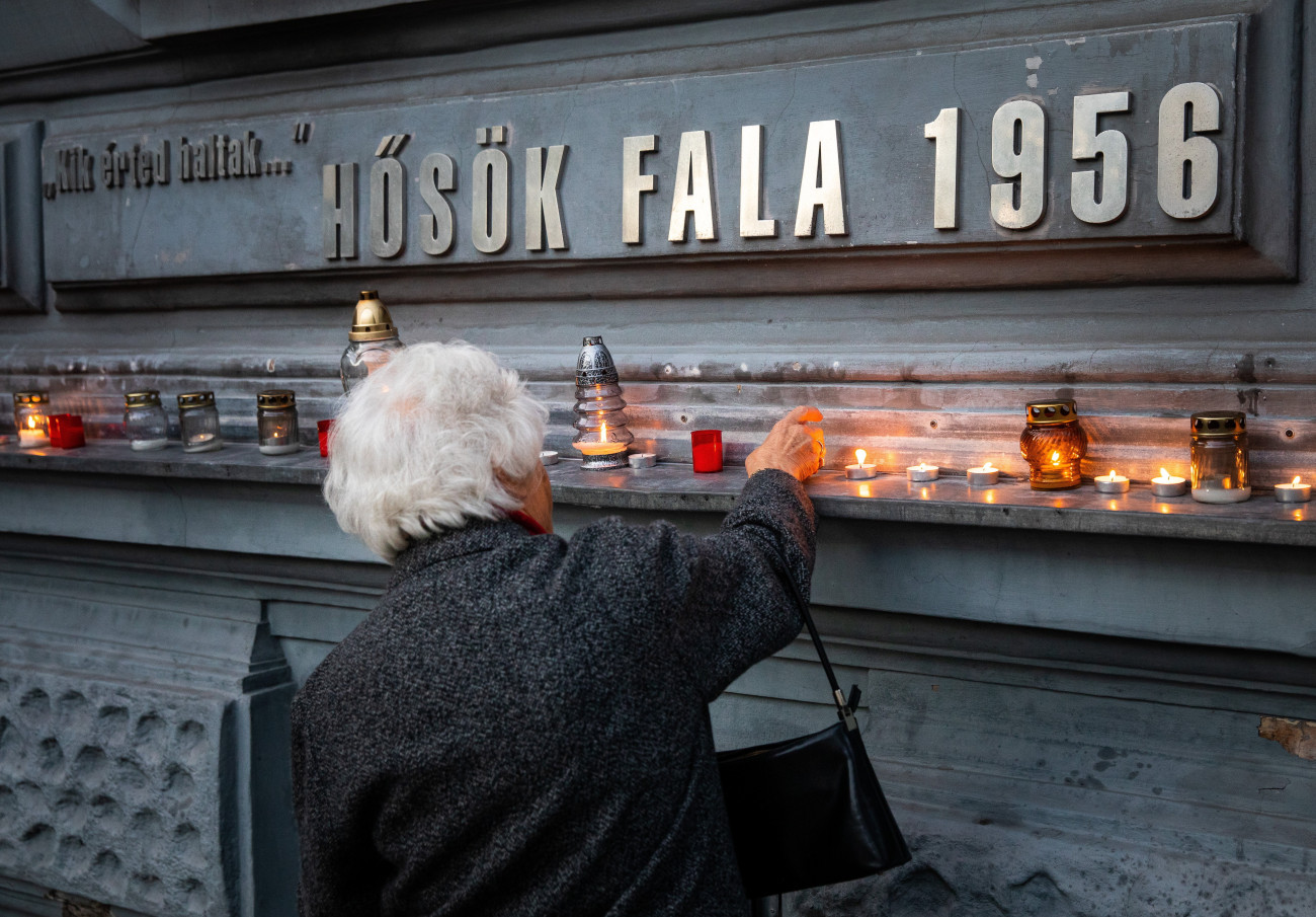 Budapest, 2021. október 23.
Egy idős nő mécsest gyújt a Terror Háza Múzeum Hősök falánál az 1956-os forradalom és szabadságharc 65. évfordulóján, 2021. október 23-án.
MTI/Mohai Balázs