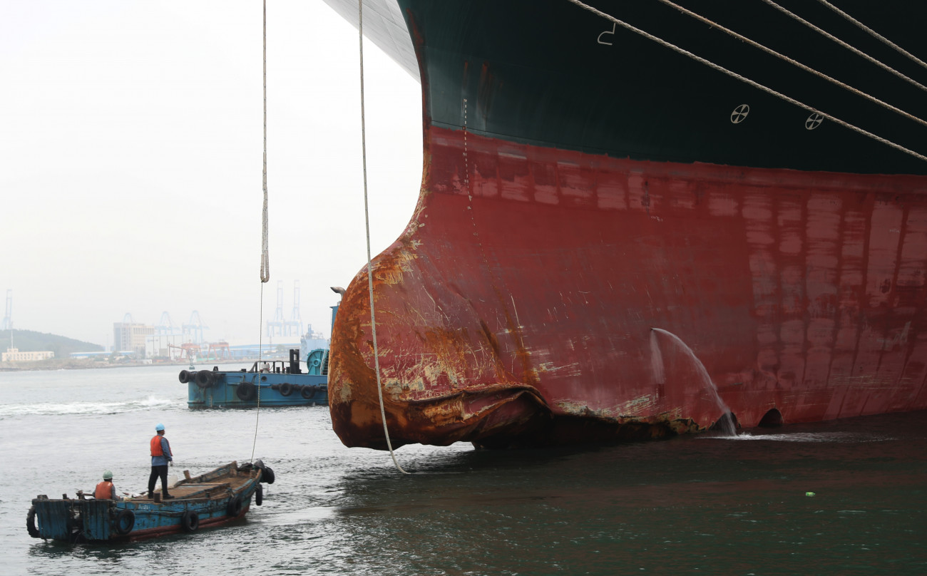 QINGDAO, CHINA - OCTOBER 04 2021: Workers approach the damaged bow of the Evergreen container ship Ever Given, arriving at a shipyard for repair, in Qingdao in east China's Shandong province Monday, Oct. 04, 2021. The ship ran aground in the Suez Canal in March, blocking the traffic for 6 days. (Photo credit should read Feature China/Barcroft Media via Getty Images)
